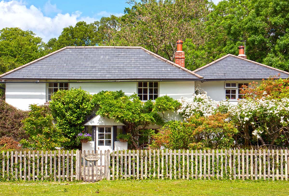 Bungalow with slate roofing and copper ridges on a sunny day